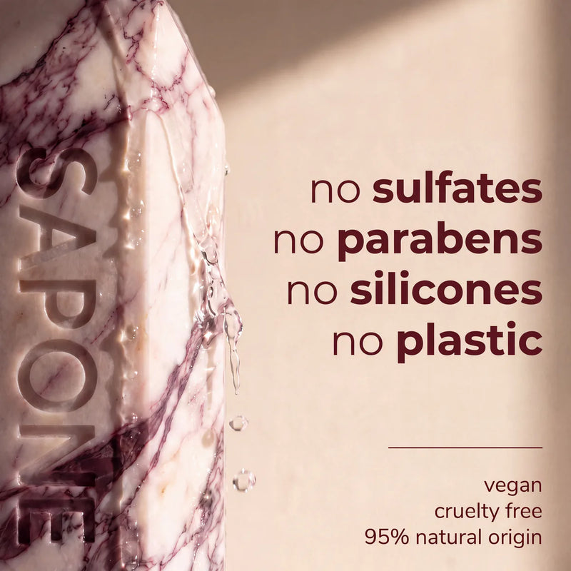 A close-up of a wet Sapone bottle. The formula has no sulfates, parabens, silicones or plastic, and is vegan, cruelty free and 95% natural in origin.